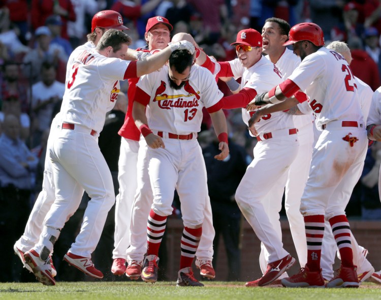 The Cardinals' Matt Carpenter is congratulated by teammates after his 11th-inning grand slam gave host St. Louis an 8-4 victory over the Blue Jays in the first game of a doubleheader on Thursday. The Cardinals won the night game, 6-4.