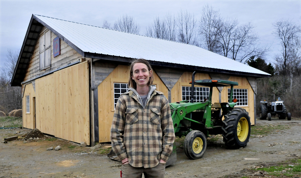 Farmer Johanna Davis stands in front of a barn Tuesday at her Songbird Farm in Unity. Songbird Farm is one of 10 in the country to receive a sustainability grant from The FruitGuys Community Fund. The farm received $2,966 to build a rainwater collection system. The system will help the farm conserve water, which will be an advantage in times of drought.
