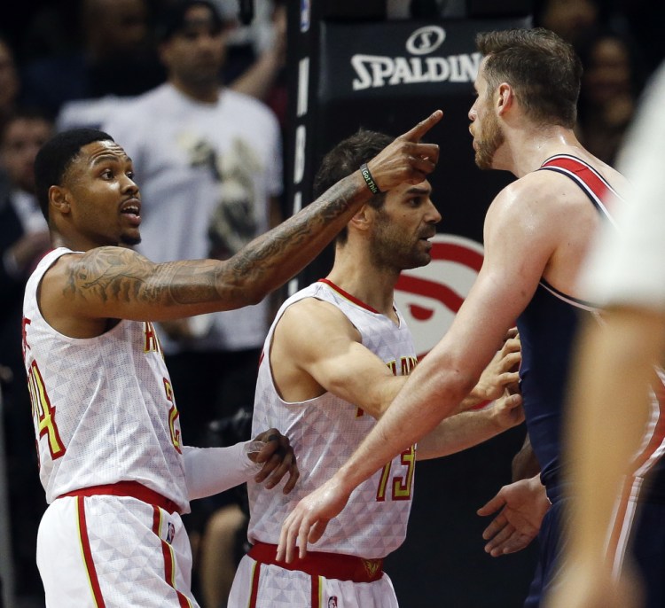 Kent Bazemore of the Atlanta Hawks, left, exchanges words with Jason Smith of the Washington Wizards during the first half of Washington's clinching victory.
