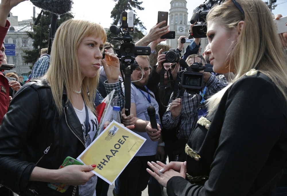 Opposition activist Maria Baronova, left, and pro-Kremlin political activist Maria Katasonova meet before an unsanctioned protest in downtown Moscow on Saturday. (Associated Press photos)