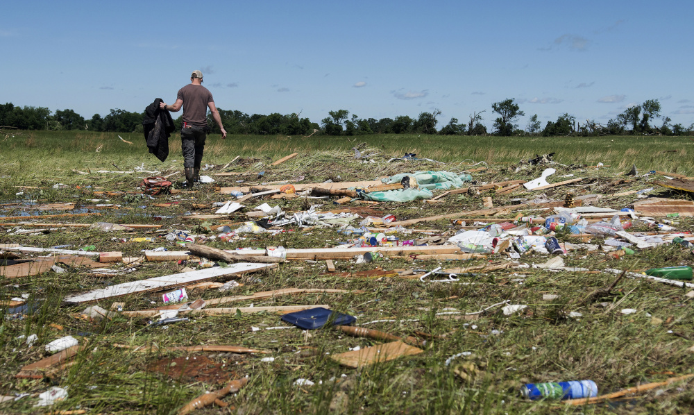 Kyle Allen walks his parents' property in Canton, Texas, on Sunday, looking for personal items. Severe storms, including tornadoes, swept through towns in East Texas on Sunday, killing several people, authorities said.