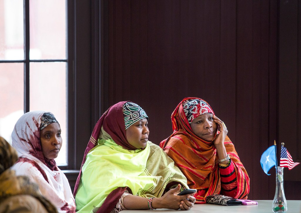 Lewiston residents Halima Mohamed, left, Khadijo Ibrahim and Jowhar Kabir, right, listen to Stephen Schwartz, U.S. ambassador to Somalia, at his public meeting in Lewiston on Thursday.