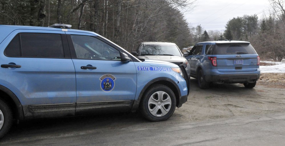 Maine State Police cruisers are parked at the end of a driveway on South Horseback Road in Burnham.