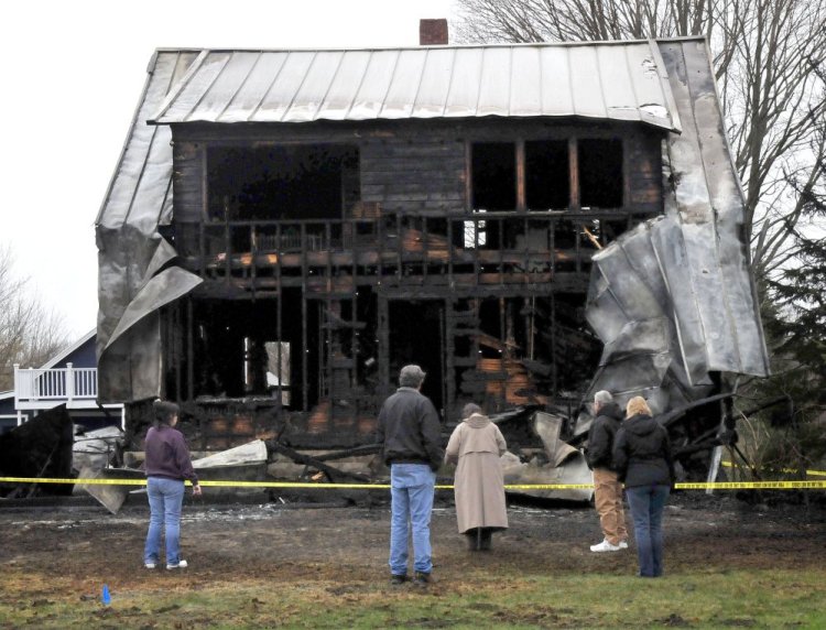 People survey the remains of this home on Main Street in Vassalboro Thursday morning that was destroyed by fire the previous night. The woman at far left is reportedly the owner.