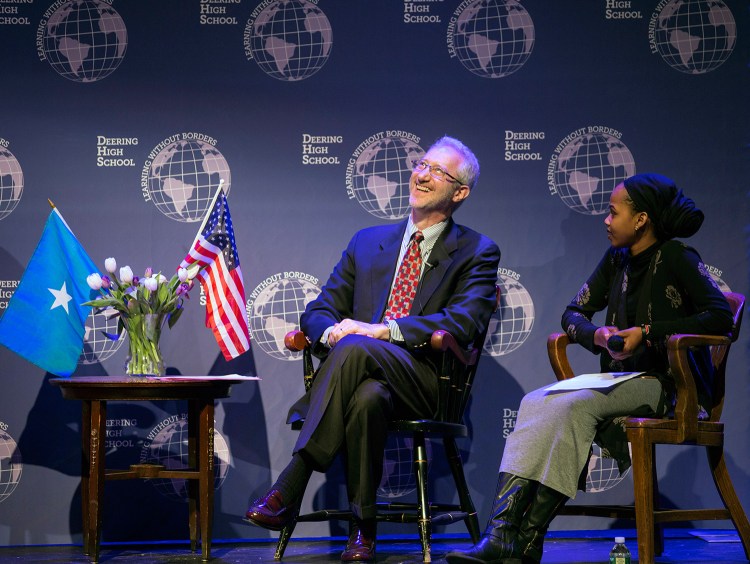 Ambassador Stephen Schwartz thinks about his answer to a question by Deering High School junior Amran Mahamed, right, one of the moderators for Wednesday night's discussion at the school.