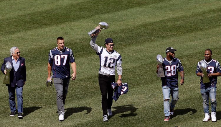 New England Patriots owner Robert Kraft, and players Rob Gronkowski, Tom Brady, James White and Dion Lewis display the team's five Super Bowl trophies before the Red Sox opening day game on April 3.