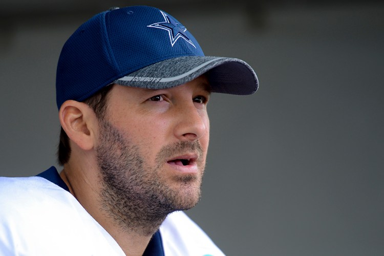 Tony Romo talks to reporters at the end of a team practice in Oxnard, Calif., last September. Romo, who turns 37 this month, was trying to recover from a series of back injuries that included two surgeries in less than a year.