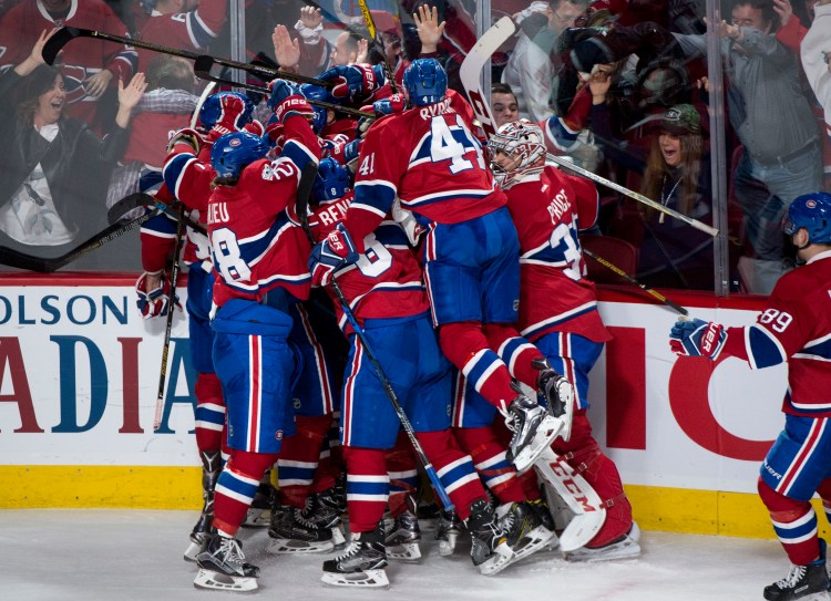Montreal players pile on Alexander Radulov after he scores the winning goal against the New York Rangers in OT Friday night in Game 2 of their playoff series.