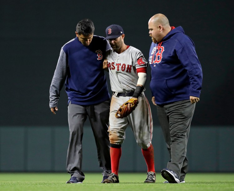 Red Sox second baseman Dustin Pedroia is assisted off the field after being injured during the eighth inning of Friday night's game in Baltimore.