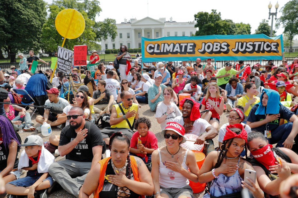 Demonstrators sit on the ground along Pennsylvania Avenue in front of the White House on Saturday during the People's Climate March. 