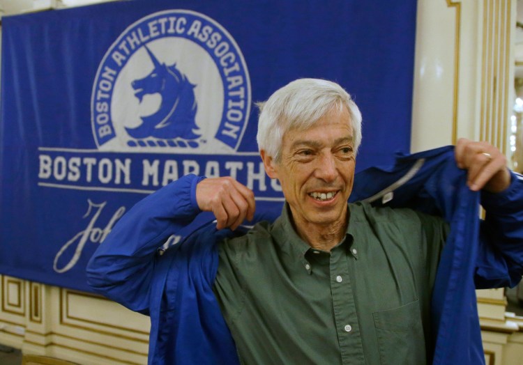 Ben Beach dons a Boston Marathon jacket before a media availability begins at the Copley Plaza Hotel near the Boston Marathon finish line Thursday in Boston. Beach is on the verge of becoming the first person to run the Boston Marathon 50 consecutive times if he completes the race on Monday.