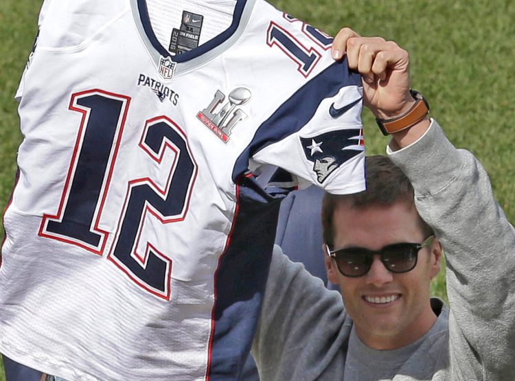 Tom Brady displays his recovered jersey during pregame ceremonies before the Red Sox opener at Fenway on Monday. 