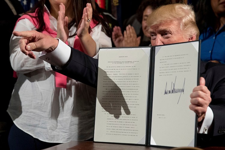 President Trump holds up an executive order in Washington on Thursday.