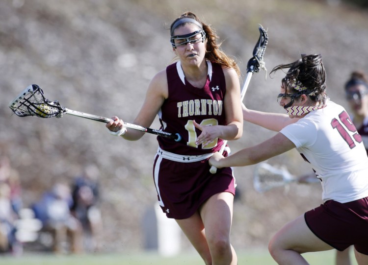 Amanda Cyr of Thornton Academy attacks the net Tuesday as Athena Pappalardo of Gorham defends during their girls' lacrosse game at Gorham High. Cyr and Pappalardo each scored two goals in Thornton's 11-6 victory.