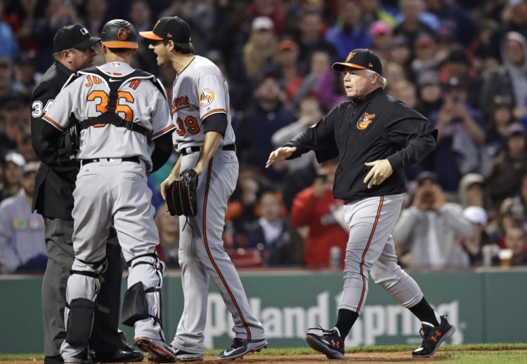 Orioles Manager Buck Showalter, right, rushes to home plate as starting pitcher Kevin Gausman argues with umpire Sam Holbrook after hitting Boston's Xander Bogaerts with a pitch in the second inning Wednesday night at Fenway Park. Gausman was ejected on the play.