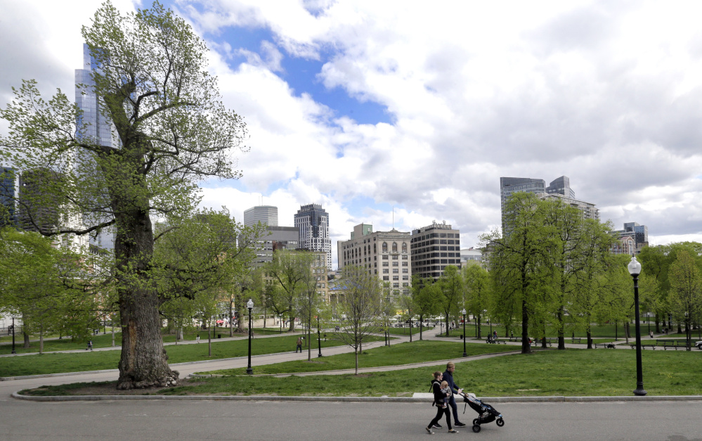 A couple walks with a child in the Boston Common, a 50-acre park founded in 1634 in downtown Boston. A proposed skyscraper would throw shade of the Common and the neighboring Public Garden, but in exchange the city would get a windfall payday.