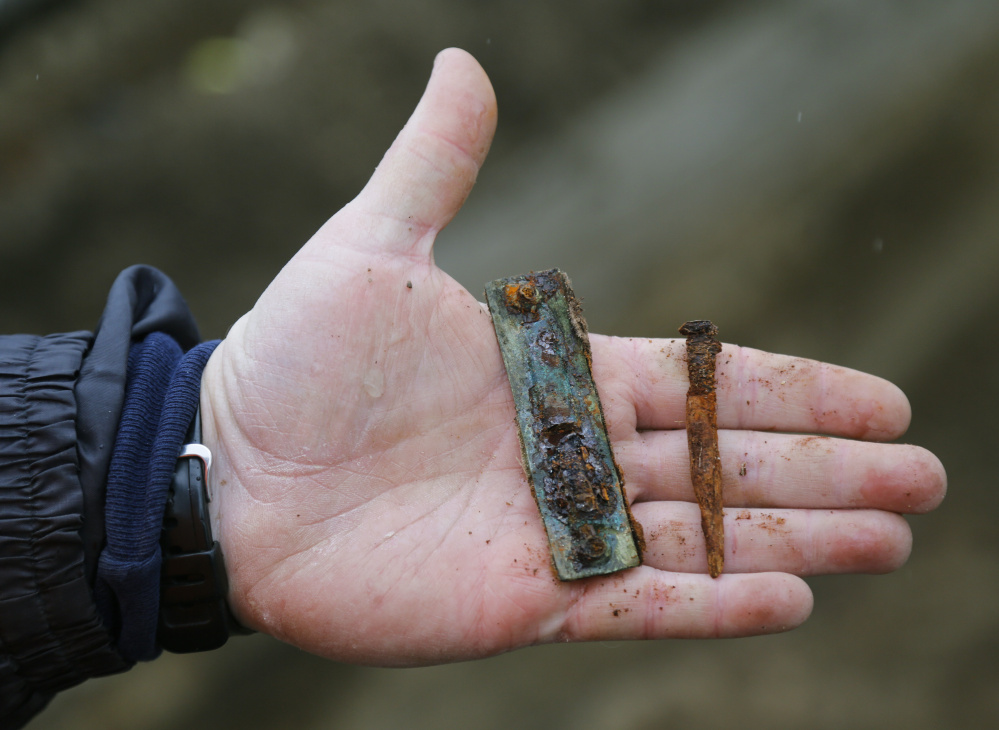 Paul Auger holds a nail and a bracket from a grave discovered at a construction site on Main Street. Auger estimates that the grave is from sometime between 1880 and 1906.
