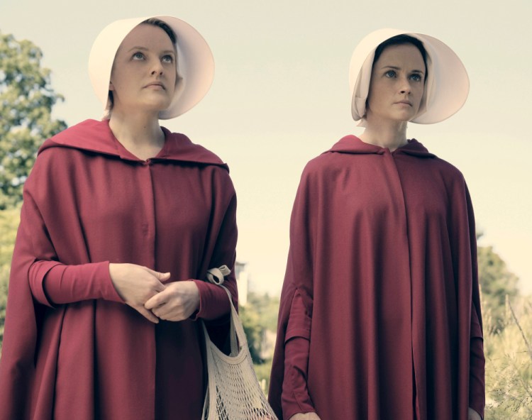 Elisabeth Moss, left, as Offred and Alexis Bledel as Ofglen in the Hulu series "The Handmaid's Tale," based on the novel by Margaret Atwood.