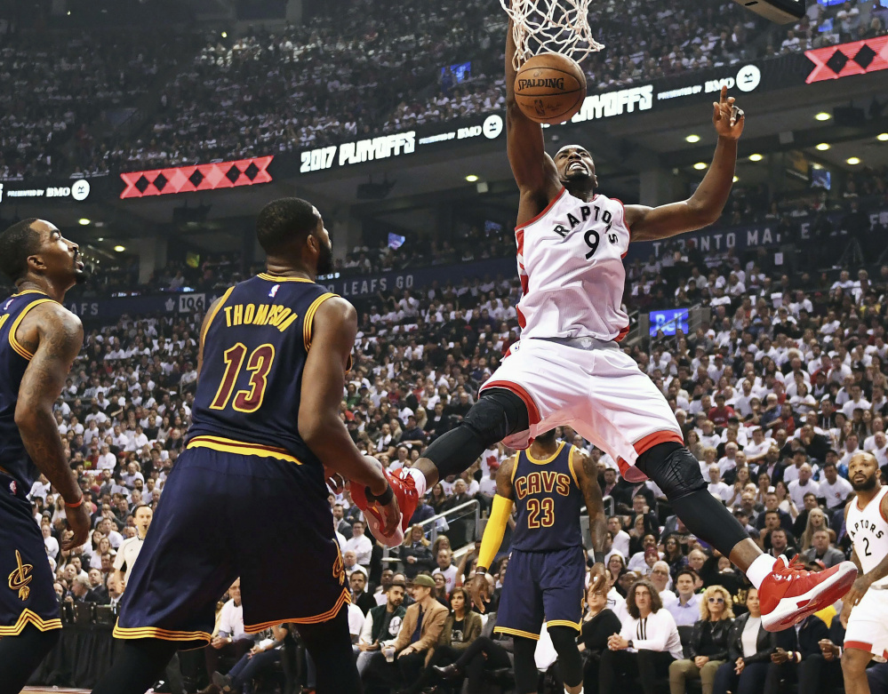 Toronto Raptors forward Serge Ibaka dunks as Cleveland Cavaliers guard JR Smith and center Tristan Thompson  look on during the first half of Game 3 of an NBA second-round playoff series in Toronto on Friday.