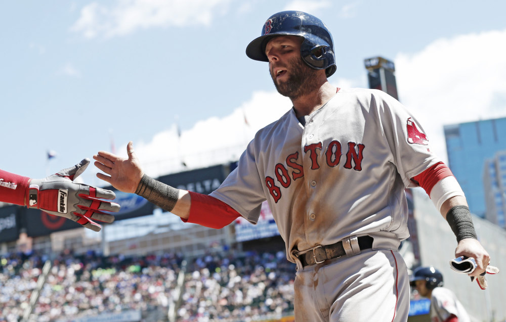 Boston's Dustin Pedroia is congratulated at the dugout after scoring on a two-run double by Andrew Benintendi in the second inning of Saturday's game in Minneapolis. Boston won, 11-1. (Associated Press/Jim Mone)