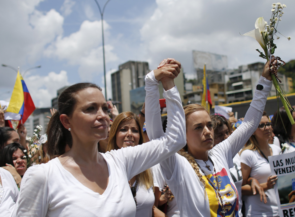 Opposition leader Maria Corina Machado, left, and Lilian Tintori, wife of jailed opposition leader Leopoldo Lopez, lead a women's march in Caracas on Saturday. 