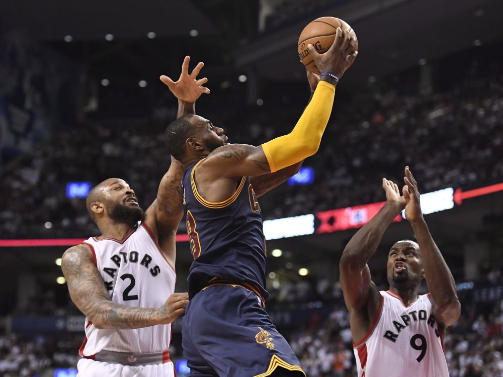 Cleveland forward LeBron James drives to the basket while being defended by Toronto's P.J. Tucker, left, and Serge Ibaka during Game 4 on Sunday in Toronto. James scored 35 points and the Cavs swept Toronto with a 109-102 win.
