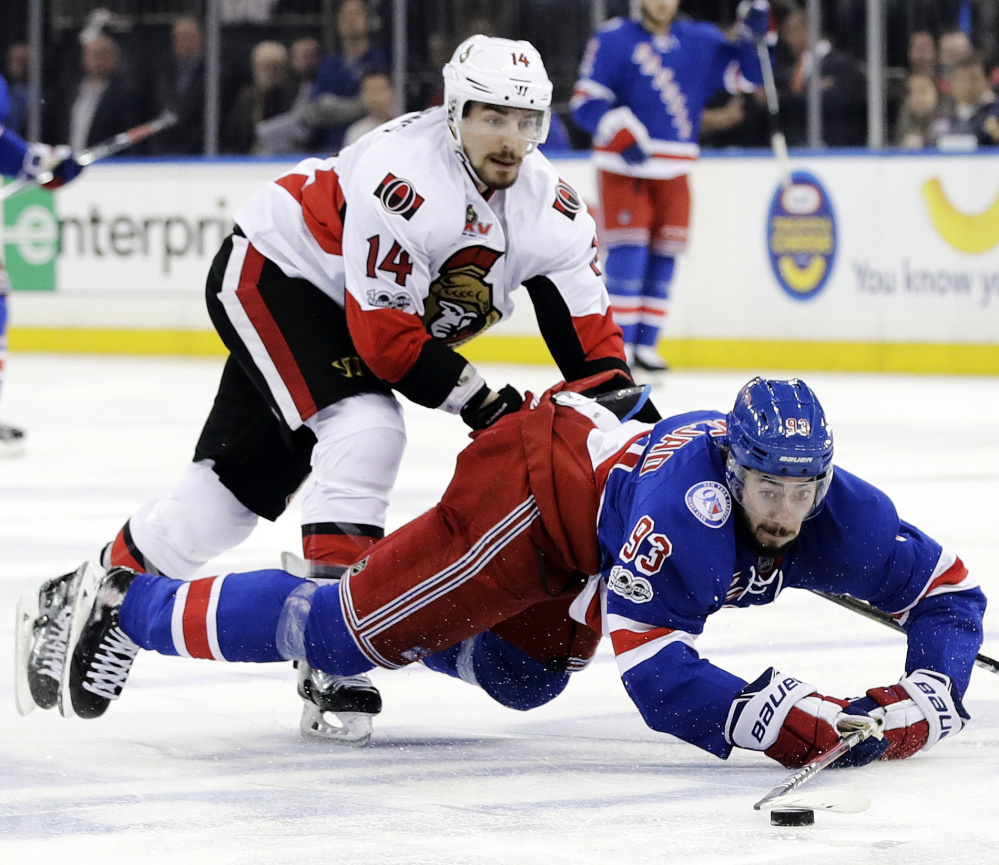 Mika Zibanejad of the Rangers goes to the ice as Ottawa's Alex Burrows pursues the puck in the second period Tuesday night in New York. Ottawa won 4-2 to take the series in six games.
