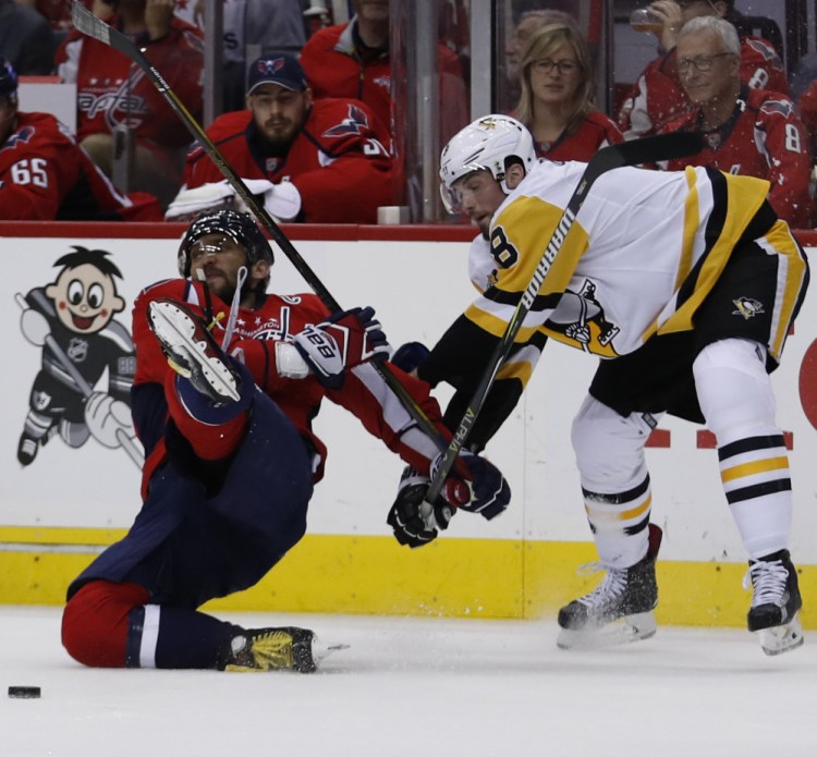 Capitals left wing Alex Ovechkin is taken to the ice by Penguins defenseman Brian Dumoulin of Biddeford during the second period of Game 7 of their playoff series Wednesday in Washington. The Penguins scored 14 seconds later.
