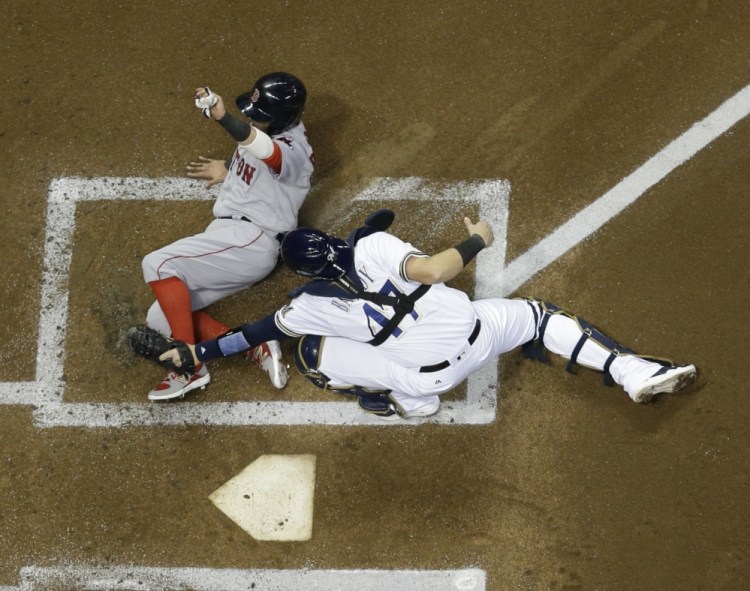 Brewers catcher Jett Bandy tags out Boston's Dustin Pedroia at home in the first inning Wednesday night in Milwaukee. Pedroia tried to score from third on a ball hit by Andrew Benintendi.
