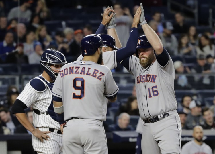 Brian McCann of the Houston Astros celebrates with Carlos Correa and Marwin Gonzalez after hitting a three-run homer in the fourth inning Friday night. Houston beat the Yankees, 5-1.