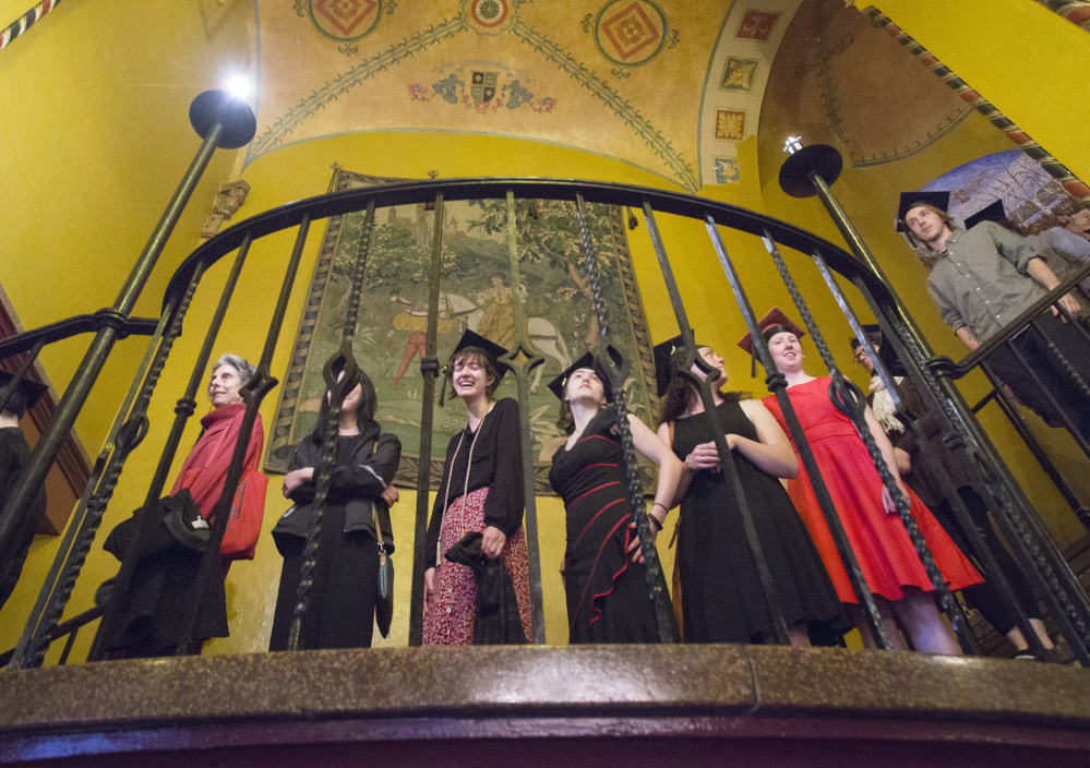 Graduates walk down the staircase before Maine College of Art's commencement Saturday at the State Theatre in Portland.