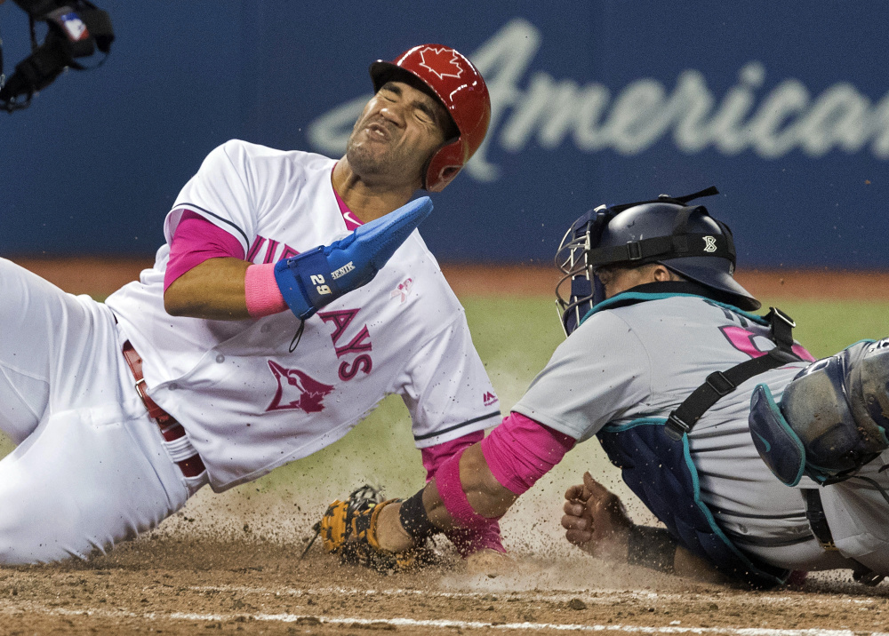 Toronto's Devon Travis steals home, beating the tag attempt by Seattle catcher Carlos Ruiz in the eighth inning of the Blue Jays' 7-2 win Saturday in Toronto.
