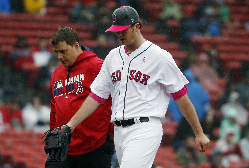 Red Sox starting pitcher Drew Pomeranz, right, leaves the field with a trainer during before the fourth inning Boston's 11-2 loss to Tampa Bay on Sunday in Boston.