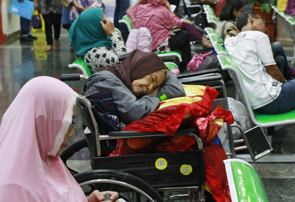 A patient takes a nap on her wheelchair as she waits with others at the registration desk at Dharmais Cancer Hospital in Jakarta, Indonesia, on Monday. A global cyber extortion scheme created chaos in 150 countries and could wreak even greater havoc as more malicious variations appear.