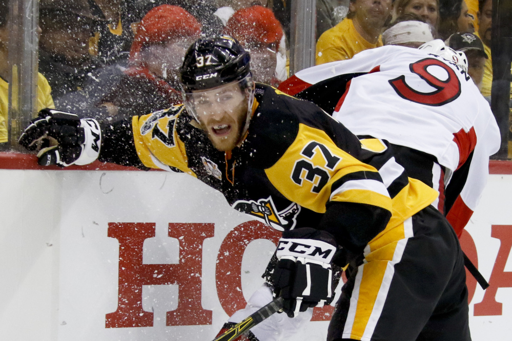 Pittsburgh's Carter Rowney, left, and Ottawa's Bobby Ryan battle along the boards during the second period of Game 2 of the Eastern Conference final Monday night.
