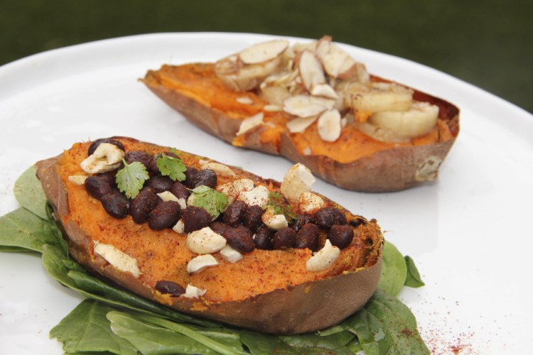 Two halves of a sweet potato prepared with savory and sweet toppings.
