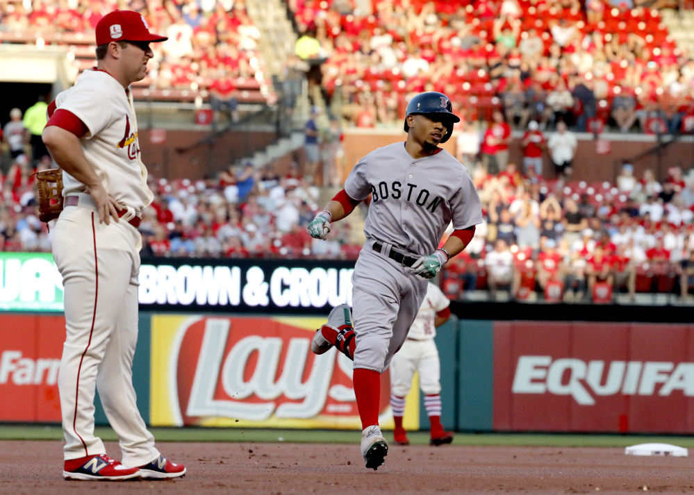 Boston's Mookie Betts rounds the bases past Cardinals third baseman Jedd Gyorko after hitting a home run to open Tuesday's game at St. Louis.