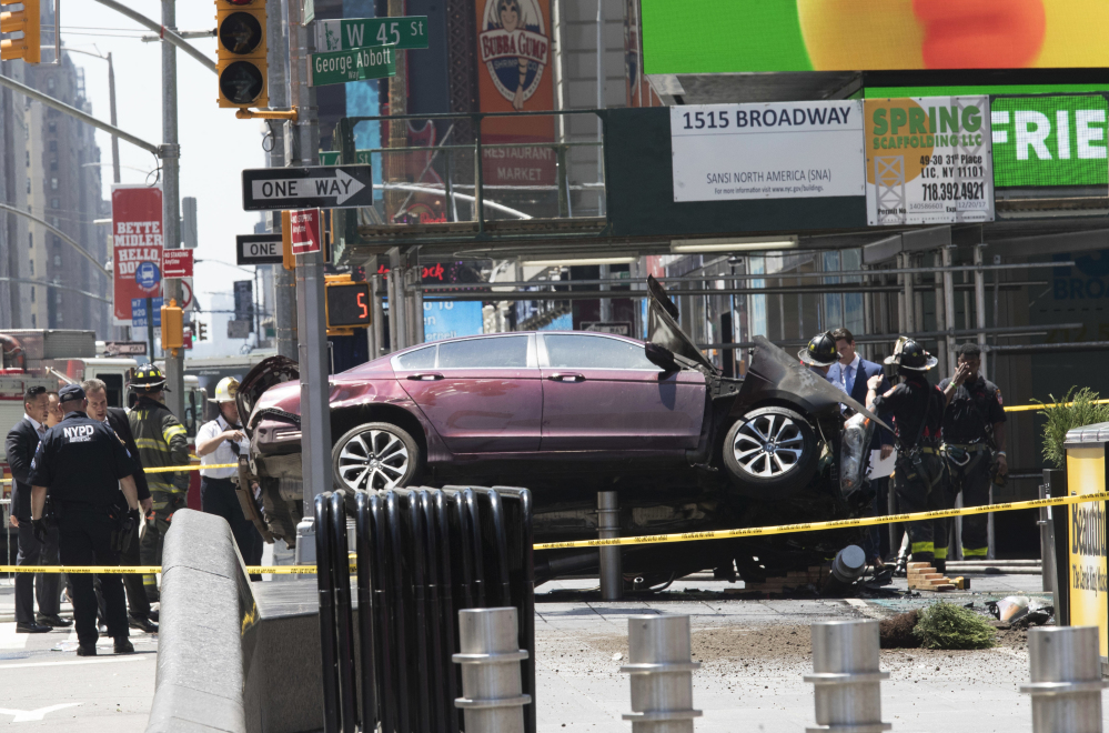 A car rests on a security barrier in New York's Times Square after plowing through a crowd of pedestrians on Thursday.