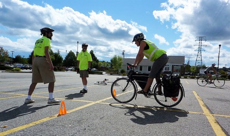 Instructors in a CyclingSavvy class work with a bicyclist on emergency braking. The national program is intended for both novice and experienced bike riders.