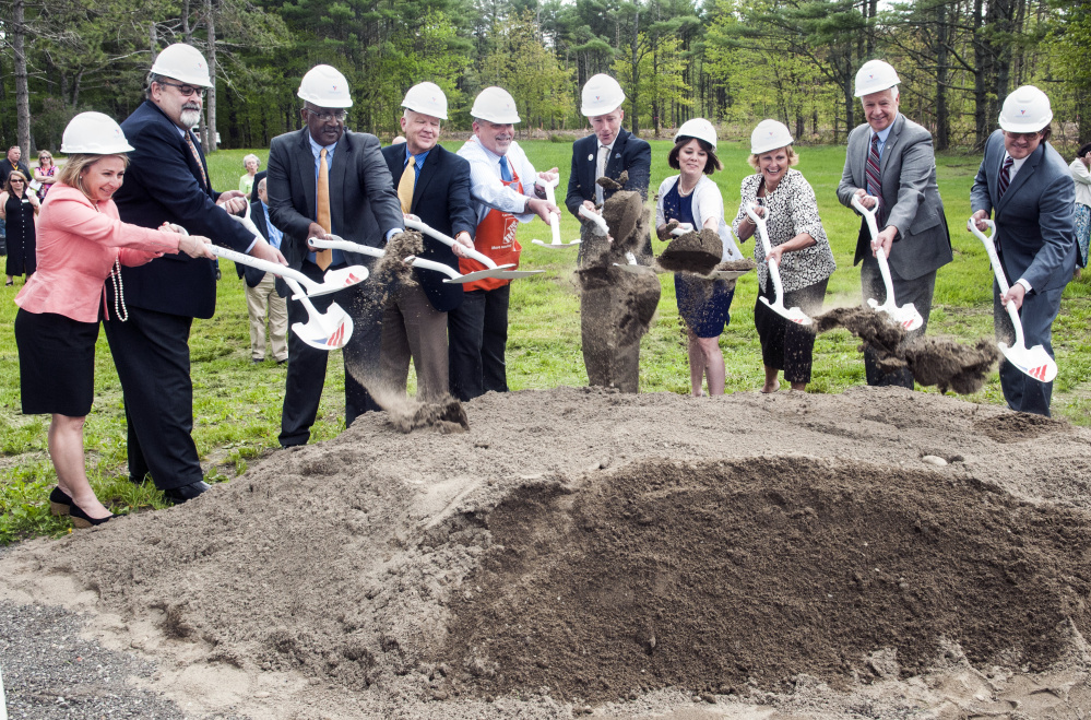 Dignitaries toss a ceremonial shovel of dirt at the Cabin in the Woods groundbreaking on Friday at VA Maine Healthcare Systems-Togus.