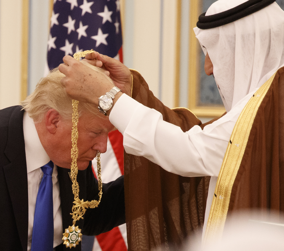 Saudi King Salman presents President Donald Trump with The Collar of Abdulaziz Al Saud Medal. At right, White House senior advisor Jared Kushner, right, enjoys the ceremony with flanked senior adviser Steve Bannon, left, and and chief economic advisor Gary Cohn.
