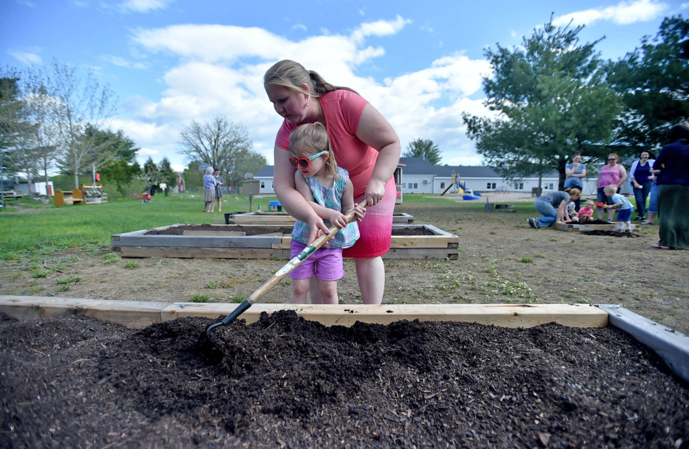 Amanda Winchenbach helps Mya Robertson, 3, prepare a soil bed at Unity Elementary School on Friday. Six staff members work with the nature-based preschool program.