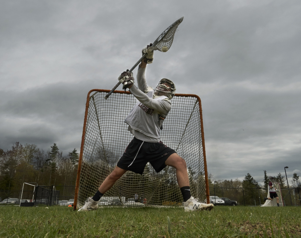 Carter Landry, Gorham High's starting goalie since his freshman year, blocks a shot during a practice last week in Gorham. Landry plans to continue playing lacrosse next year at Widener University in Chester, Pa.