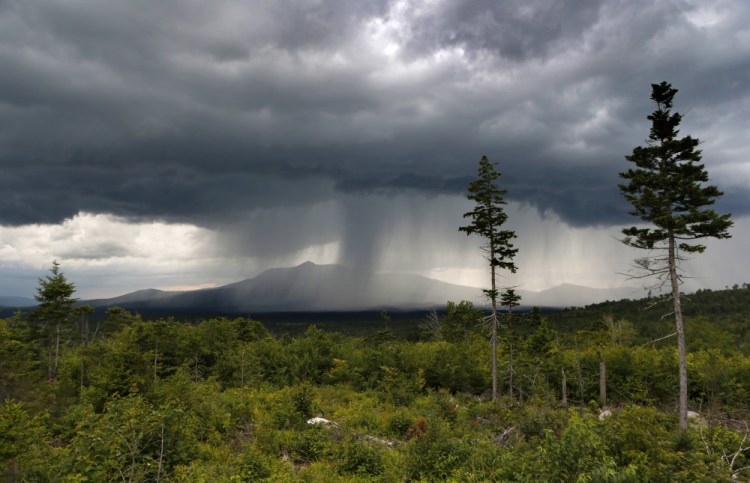 A rainstorm passes over Mount Katahdin in this 2015 view from land that is now the Katahdin Woods and Waters National Monument. Don't expect to see road signs to the monument on Interstate 95, at least not this summer.