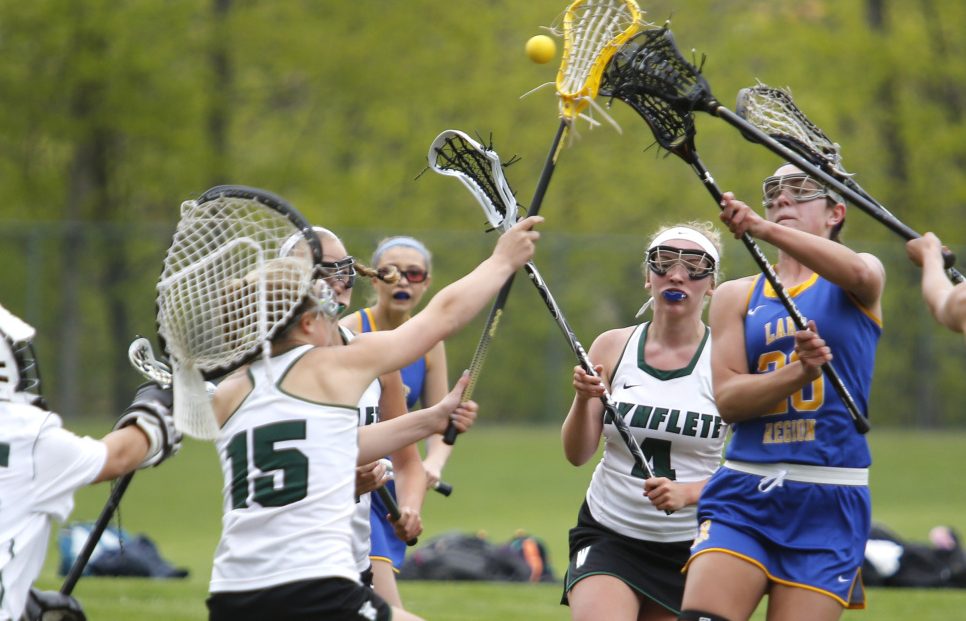 Lauren Jakobs of Lake Region tries to get off a shot as Waynflete defenders close in during the first half of Monday's girls' lacrosse game in Portland. Jakobs had two goals, but Lake Region lost in double overtime.