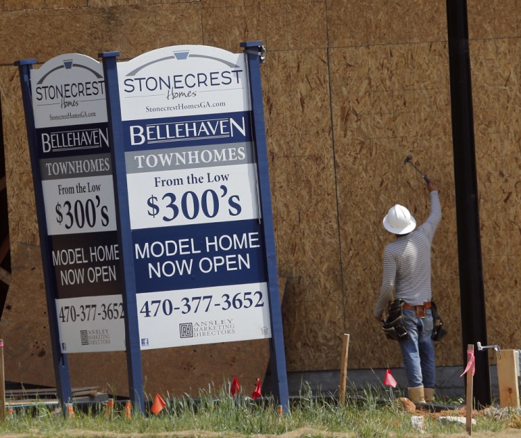 A carpenter works on a home being built in Woodstock, Ga. Some economists viewed the April drop in new-home sales as a one-month blip, expecting a rebound in May.