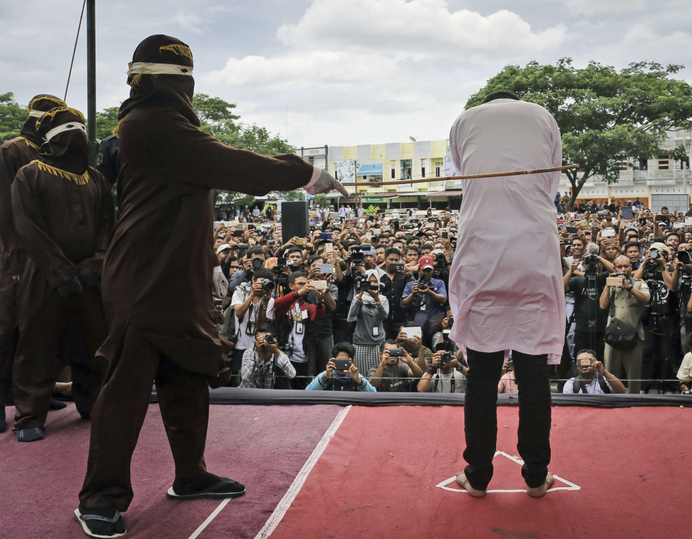 A team of five hooded Shariah law enforcers took turns caning two men for consensual gay sex in Banda Aceh, Indonesia, Tuesday. Each man was caned 83 times.