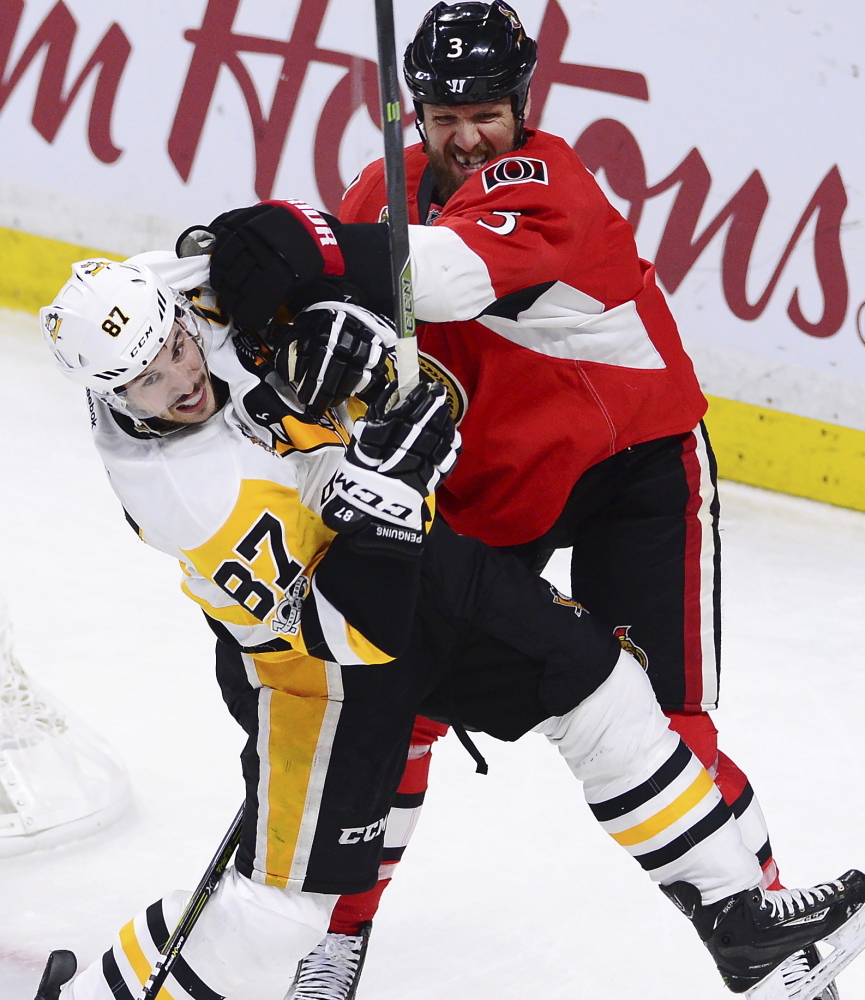 Pittsburgh center Sidney Crosby, left, takes a shove from Ottawa defenseman Marc Methot during Game 6 in Ottawa, Ontario, on Tuesday night. The Senators won, 2-1.