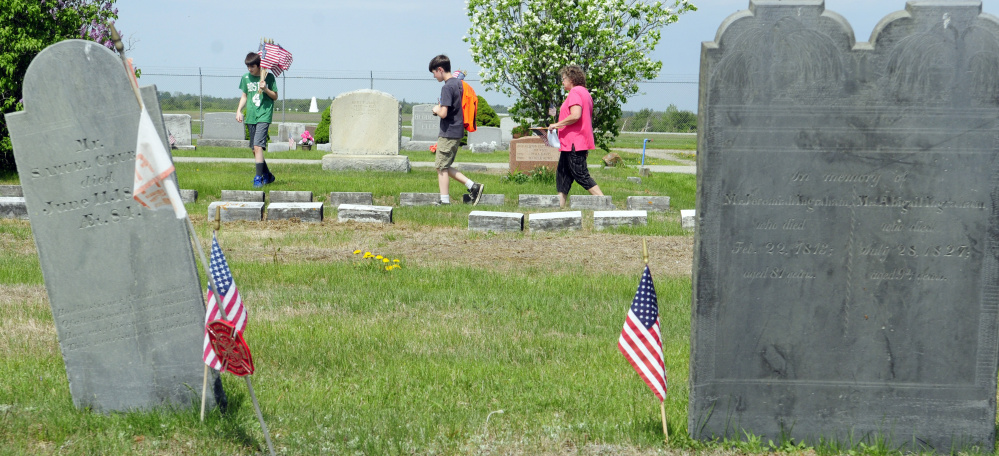 Volunteers look for veterans' graves Wednesday in Mount Hope Cemetery in Augusta.