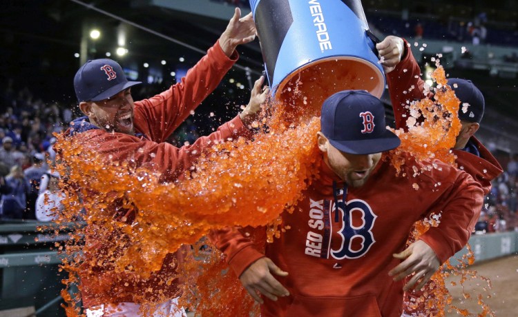Red Sox first baseman Sam Travis is doused with sports drink by pitcher Matt Barnes after Boston defeated the Texas Rangers 9-4  at Fenway Park on Wednesday. Travis played a solid first base in his major league debut.